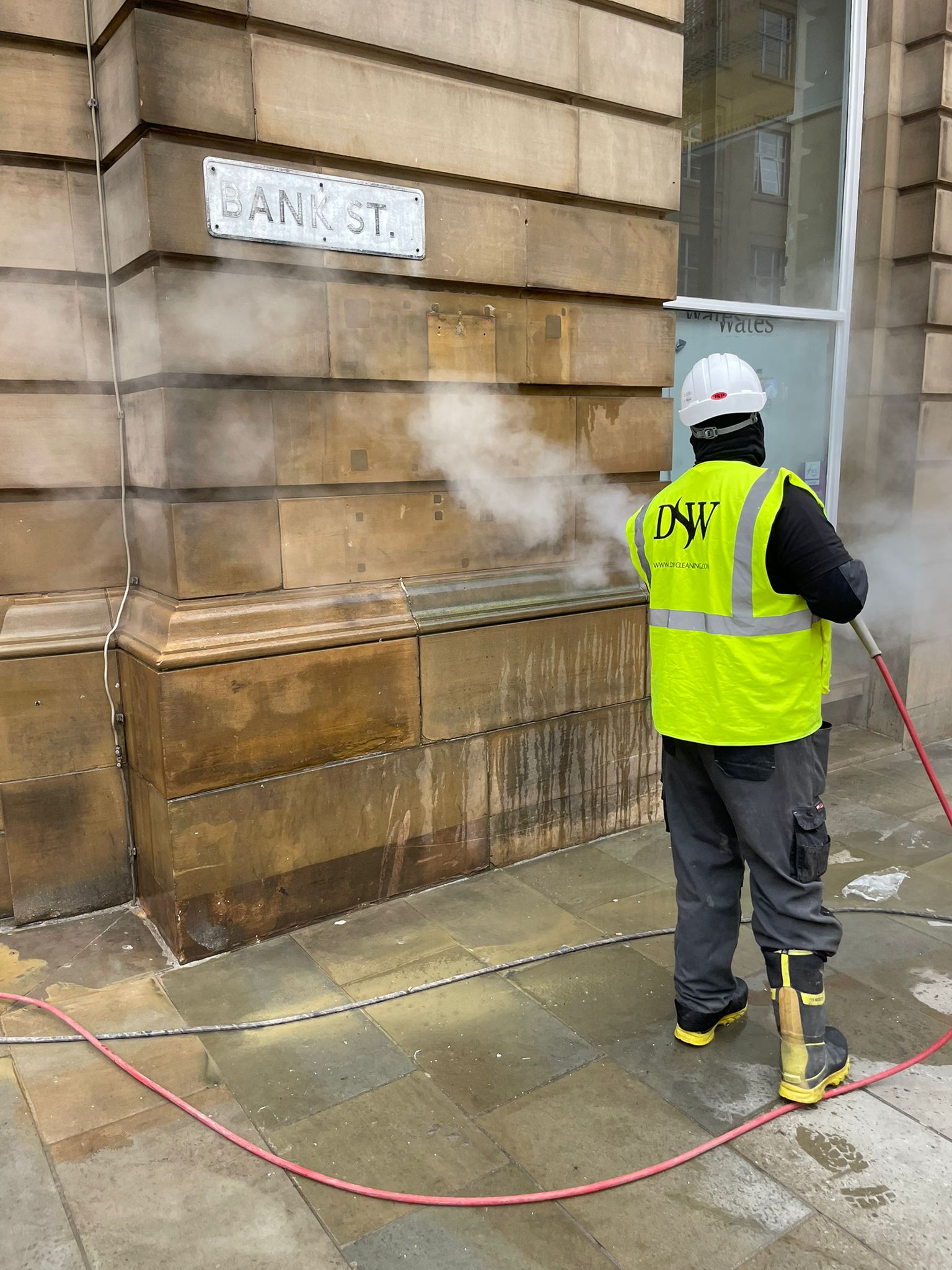 DSW Cleaning team using high-level access equipment at HSBC branch.