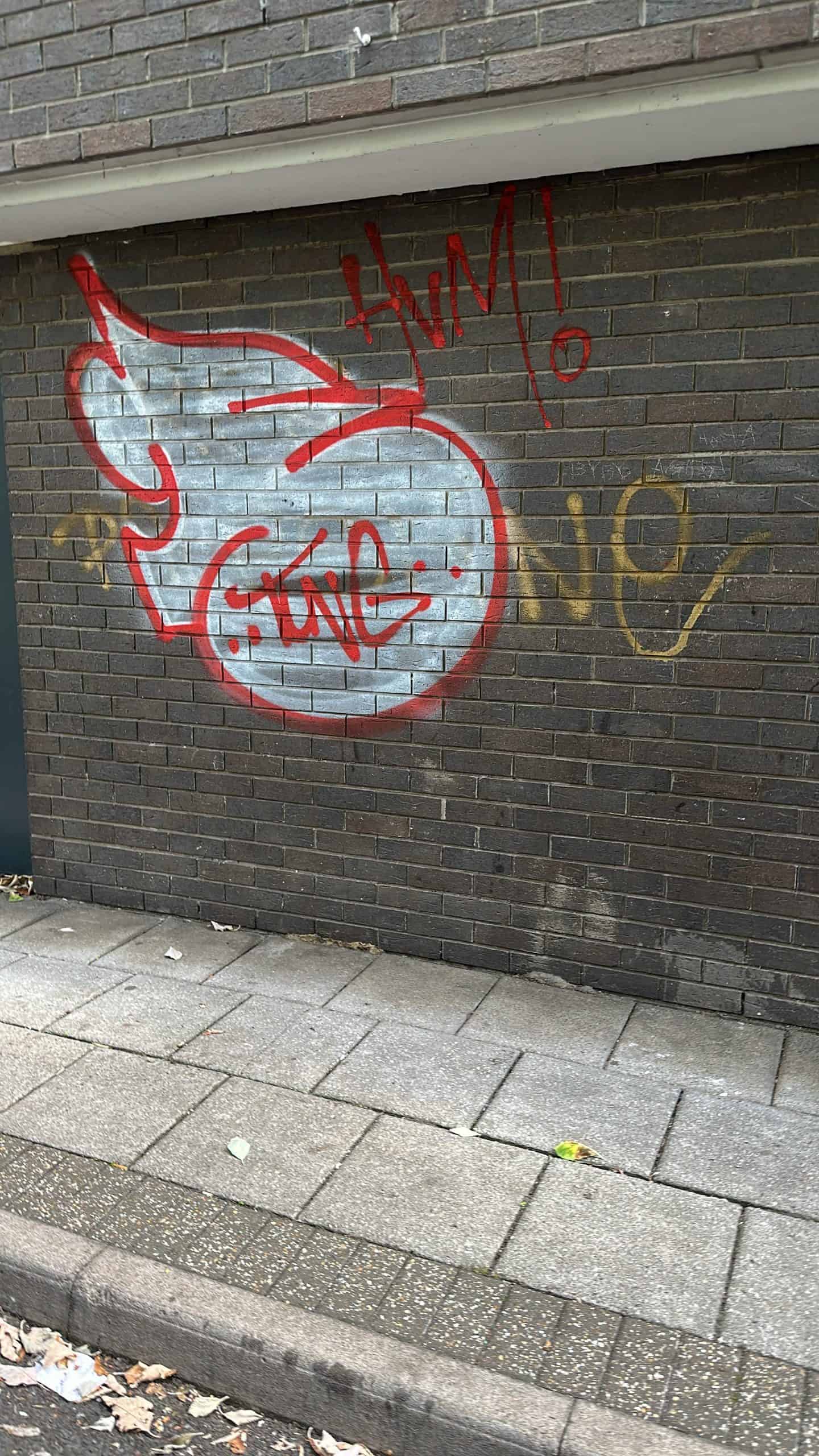 Unsightly  graffiti on brick wall on a commercial before cleaned