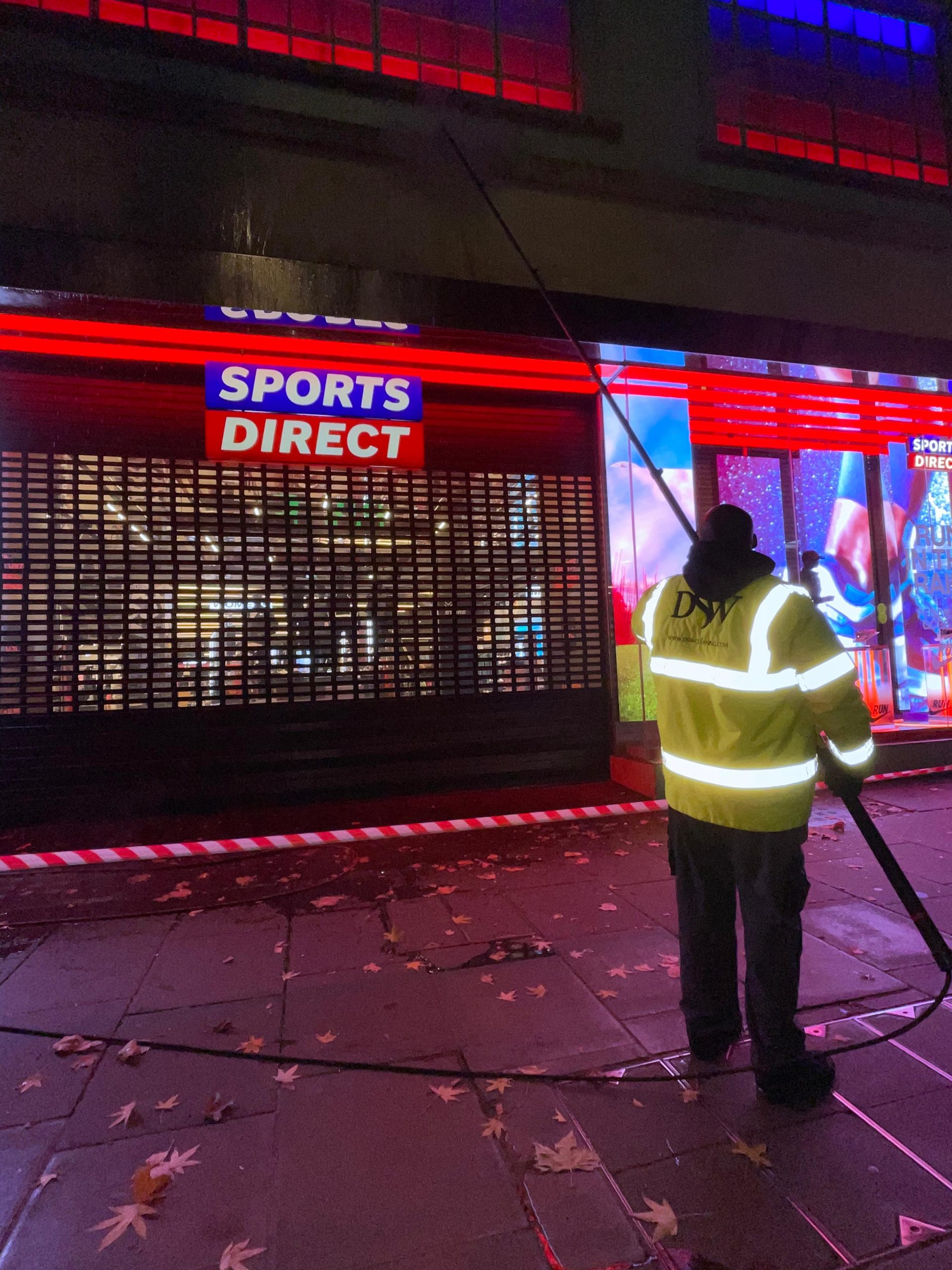 Safety barriers and signage in place during evening cleaning in a busy urban area.”