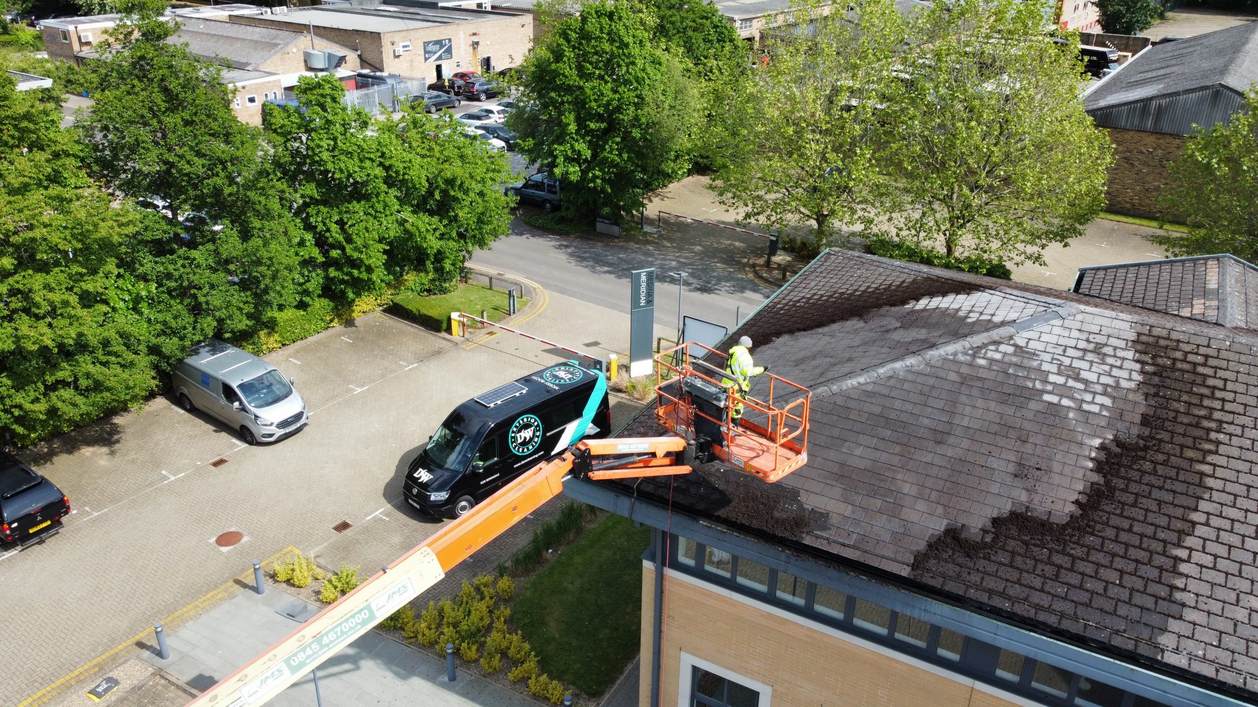 Technician cleaning roof panels at an industrial site in Marlow