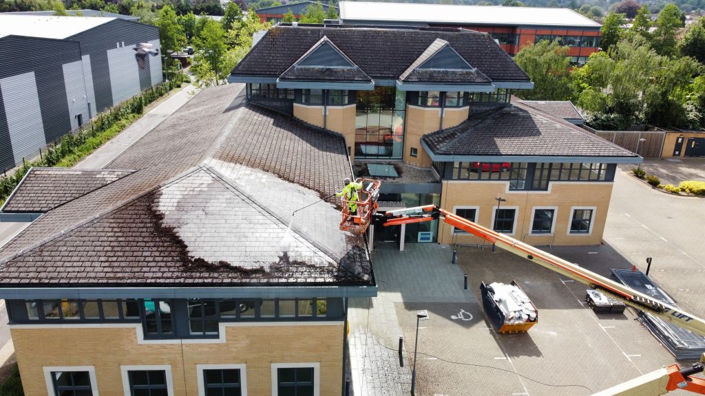 Close-up of moss and algae being safely removed from an industrial roof in Marlow.