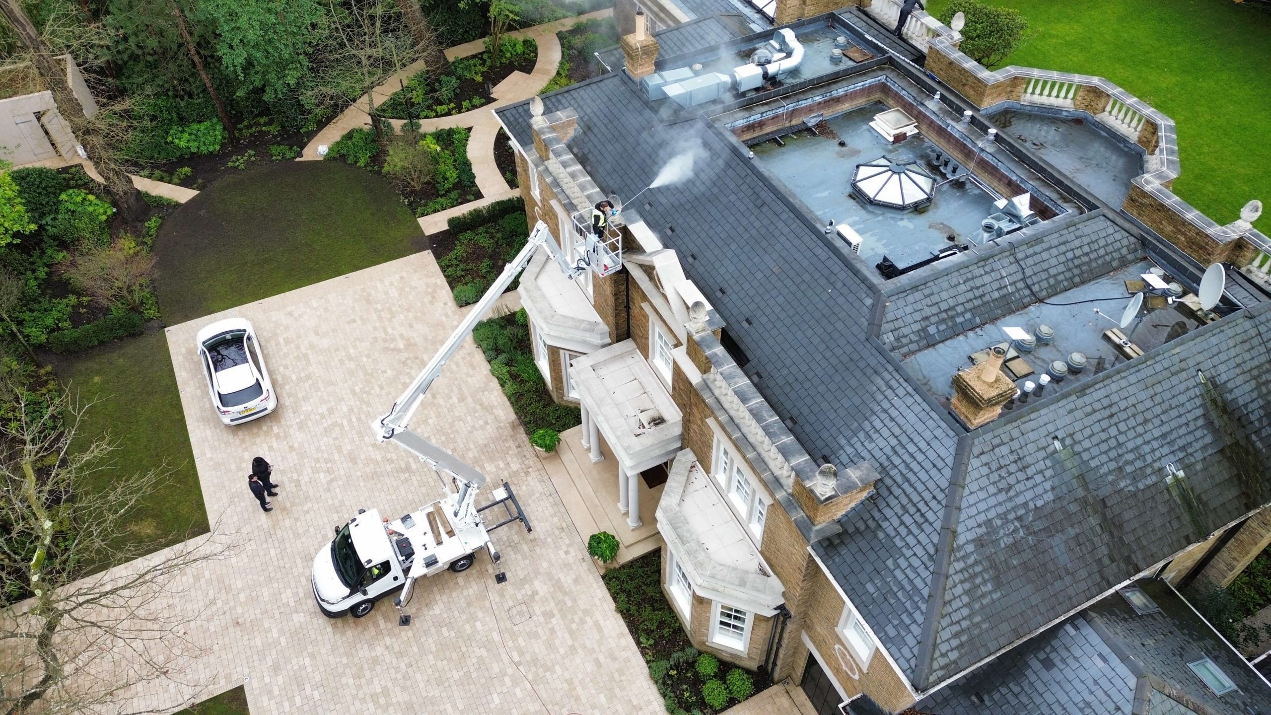 Cherry picker positioned for DOFF steam cleaning stone coping on building façade