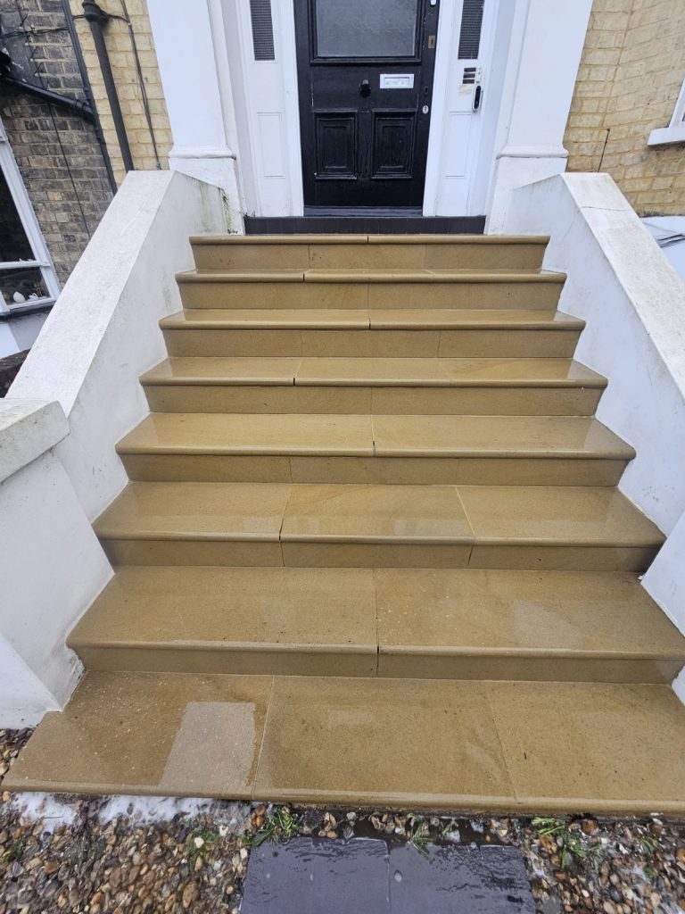 Top landing of stone staircase after professional cleaning.